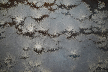 Close-Up Image of Frost Crystals Forming Intricate Patterns on a Windowpane in Winter
