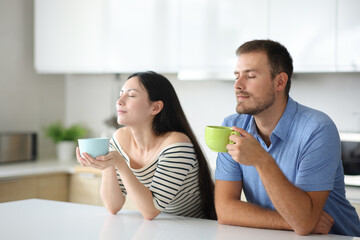 Interracial couple drinking and breathing in a house