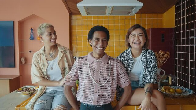Group of friends bonding at home, LGBTQ and diversity concepts - Homosexual couple and fluid gender non binary young man with cross dressing clothing style having fun in the apartment, LGBT people