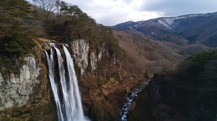 Obraz premium Scenic Shindo no Taki Falls cascading amidst lush mountains in Japan