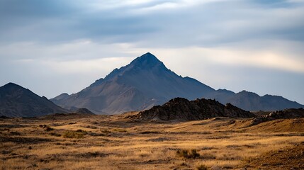 Majestic mountain peak towering over golden grassland under a tranquil sky : Generative AI