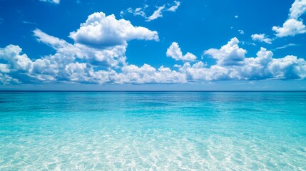 Fototapeta premium Beautiful, clear blue water and sky background with white clouds on the horizon, a beautiful tropical seascape.