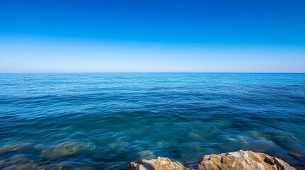 Obraz premium Tranquil view of calm blue ocean waves lapping against rocky shore under clear blue sky : Generative AI