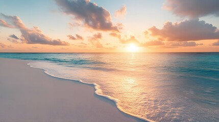 Beautiful sunset over the ocean with colorful clouds on the sandy beach in the Maldives. Panoramic view of the calm sea water and sky at the summer evening