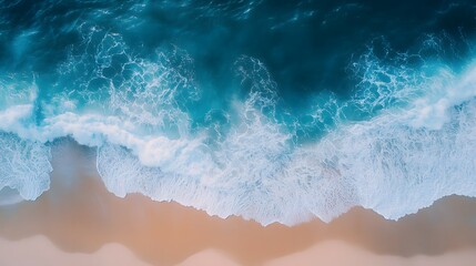 Fototapeta premium Aerial top view of ocean waves with a white sand beach in the background