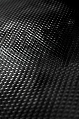 Close-up of a textured black fabric showcasing intricate patterns and depth, suitable for design