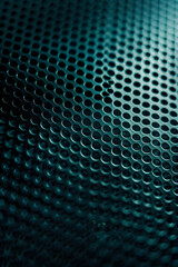 Close-up of a textured metallic surface with circular perforations, showcasing intricate patterns