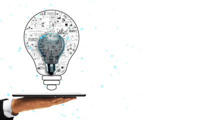 Hand holding tablet with abstract lightbulb design featuring business symbols and sketches on white background, representing innovation and creativity