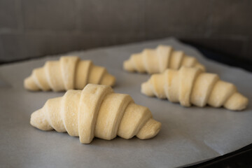 Display unbaked croissants with an application images of breakfast, brunch concepts. Showcase food preparation, bakery process. © Ann