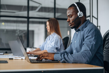 Fototapeta premium In headphones and with laptops. People are working in the call center