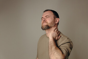 A man experiences back and neck pain due to heavy lifting or sudden movements that can cause strain and injury to the back and neck area. Safe Workout Concept