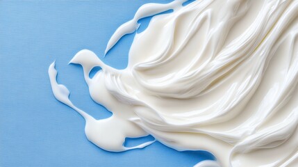 Close-Up of Creamy White Texture Spread on Soft Blue Fabric Background