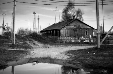 Obraz premium Black and white photo of an old wooden house in an abandoned village
