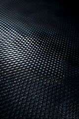 Close-up of textured dark surface with intricate patterns highlighting light and shadow play