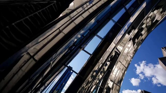 A futuristic structure made of polished metal, its exterior window capturing stunning reflection of the urban skyline.

