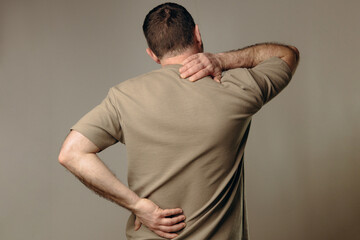 A man experiences back and neck pain due to heavy lifting or sudden movements that can cause strain...