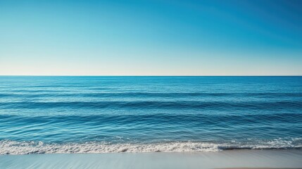 Fototapeta premium The peaceful blue sea, with light waves and a clear horizon, leaving plenty of empty space for design or text.