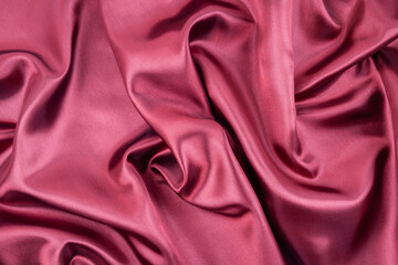 Dark deep pink abstract background. Silk satin velvet fabric.