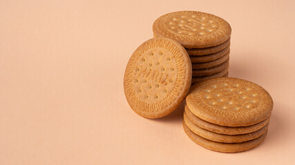 Maria biscuits on pink beige background. Trendy color of the year 2024 - Peach Fuzz. Copy space