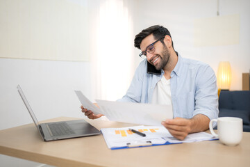 Fototapeta premium Portrait of a young freelancer smiling while working online via laptop at home