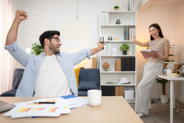 Obraz premium Portrait of a young freelancer smiling while working online via laptop at home with his girlfriend