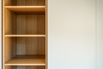 Fototapeta premium Simple minimalistic storage shelves made of wooden particleboard material, empty shelf as copy space