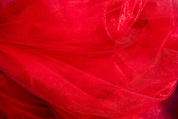 red background made of thin transparent tulle material. valentine's day. women's holiday