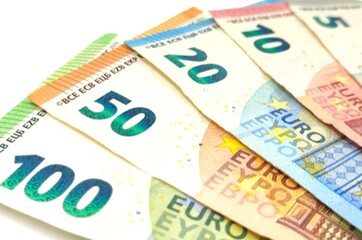 Photo of euro banknotes of all denominations, highlighting intricate details, colors, and security features, isolated on white background.