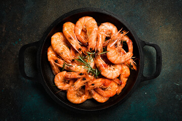 spicy roasted shrimps in cast iron pan. Seafood cooking background.