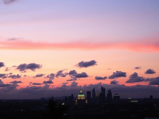 Fototapeta premium A beautiful pink clouded sky with a large round building in the center, colorful, majestic, dusk