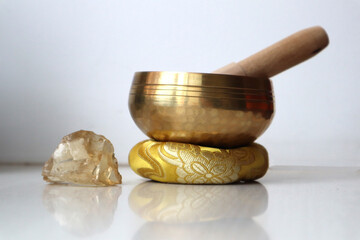 Singing bowl and citrine crystal on the table. Sound healing. Alternative therapy and relaxation.