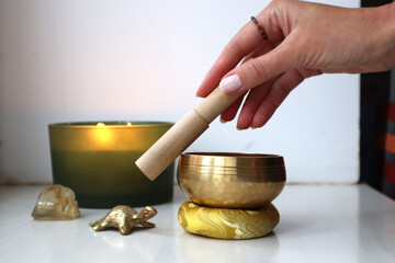 Spiritual Harmony: Meditation & Healing Rituals. Playing Tibetan bowl. Singing bowl and burning candles. Sound vibration healing.