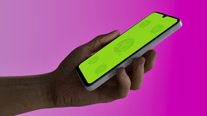 Caucasian White old male using smartphone with a blank green screen. Mobile app video mockup. Vertical phone orientation
