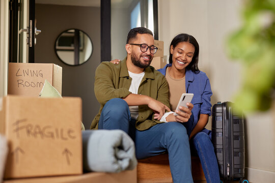 Middle eastern mid adult couple using phone after moving