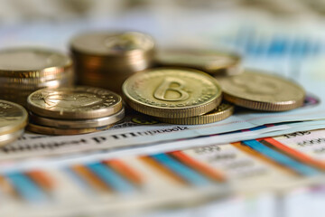 Close-up view of assorted coins and banknotes arranged on a surface with colorful patterns