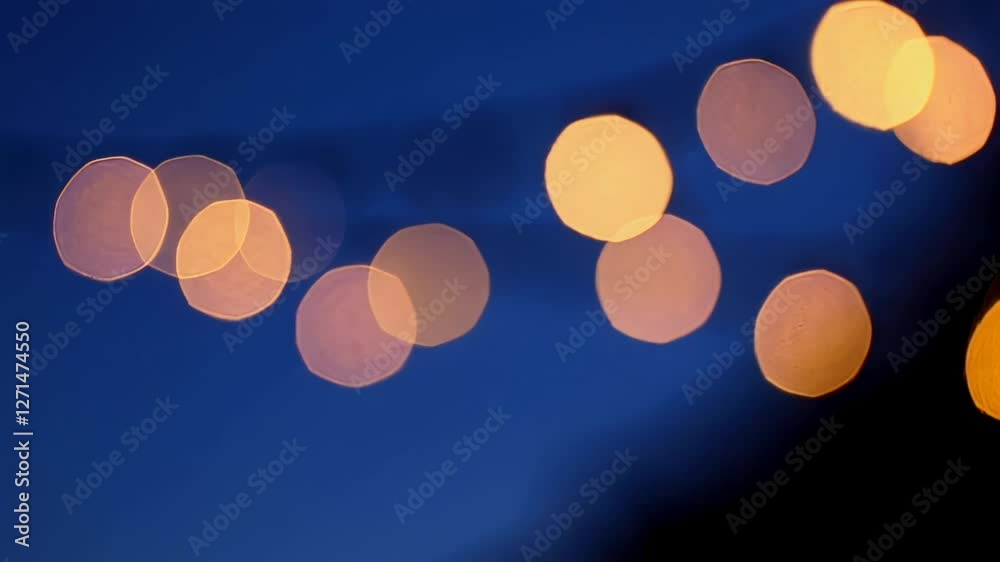 Poster Soft golden bokeh lights gently shimmering against deep blue twilight backdrop, creating ethereal dreamlike visual with mesmerizing slow motion luminosity and delicate glittering