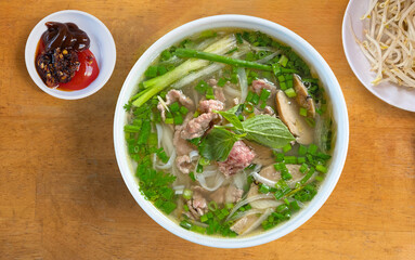 Pho Noodle Soup. Vietnam traditional pho, Beef noodles. Pho Bo Soup with beef, rice noodles, ginger, lime, chili pepper in bowl. Vietnamese cuisine.