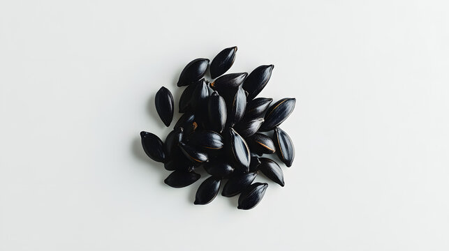 Black cumin seeds arranged carefully in a small pile on a white background, showing the distinct texture and dark color of the seeds.Black cumin seeds arranged carefully in a small pile on a white bac