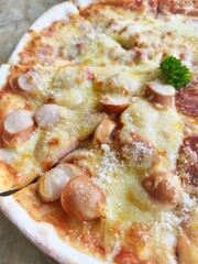 Crispy thin crust pizza topped with cheese and sausage Italian style, eight pieces placed on a wooden tray.