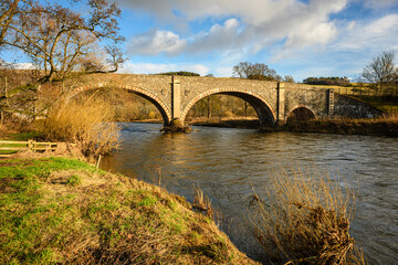 Fototapeta premium Old Tweed Bridge over River Tweed, which is 97 miles long from source to estuary and runs eastward in the Scottish Borders