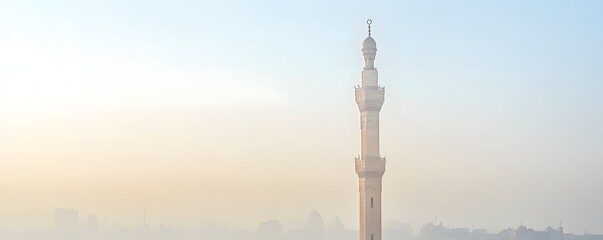 Obraz premium A minaret tower stands tall in a hazy morning light