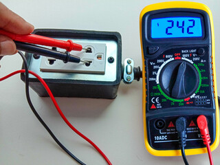 Hand holding, wire probes, and test leads of digital multimeter instrument for measuring voltage...