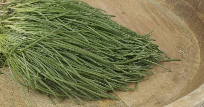 putting a bunch bundle of fresh opposite-leaved saltwort onto a wooden board closeup selective focus 4k 30fps