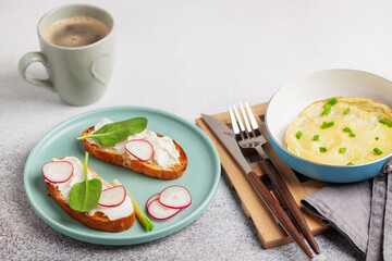 Healthy breakfast - omelette with green onions, toast with cream cheese and vegetables, coffee