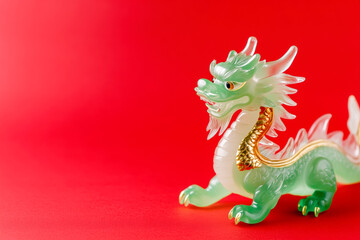 Detailed jade dragon figurine on vibrant red background symbolizing luck and prosperity in asian culture