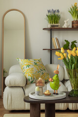 Sunny and design interior of living room with easter decorations, tulips, modular sofa, shelf,...
