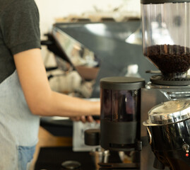 Barista Prepares Coffee at a Cozy Cafe, Showcasing Brewing Equipment and Fresh Coffee Beans