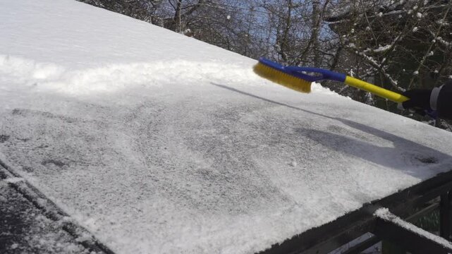 Cleaning snow from solar panels with a brush in winter