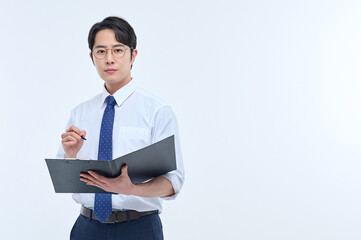 A young male teacher wearing a suit and glasses is holding a notebook in a classroom and conducting a lesson in various poses and facial expressions.