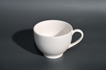 A white cup photographed against a gray background